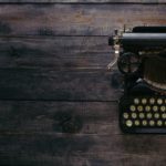 black corona typewriter on brown wooden planks