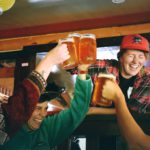 People cheering while holding mugs