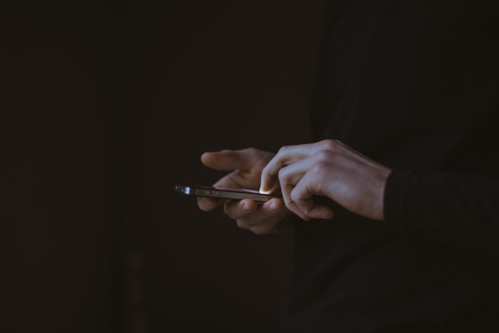 silhouette of person holding smart phone