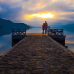 Couple on dock looking at sunset