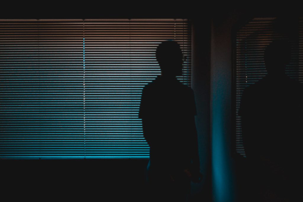 Silhouette of man near window