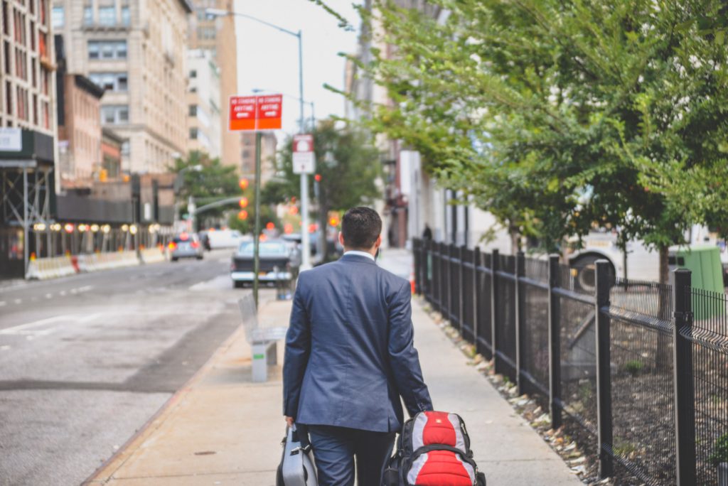 Man in suit walking beside fence