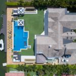 bird's eye view of house with pool near body of water