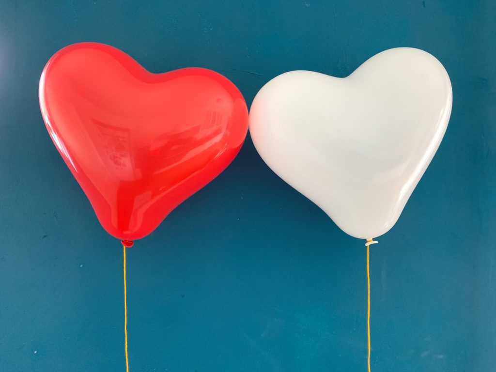 Red heart baloon on blue surface