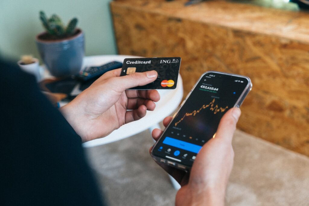 A person holding a smart phone and a credit card